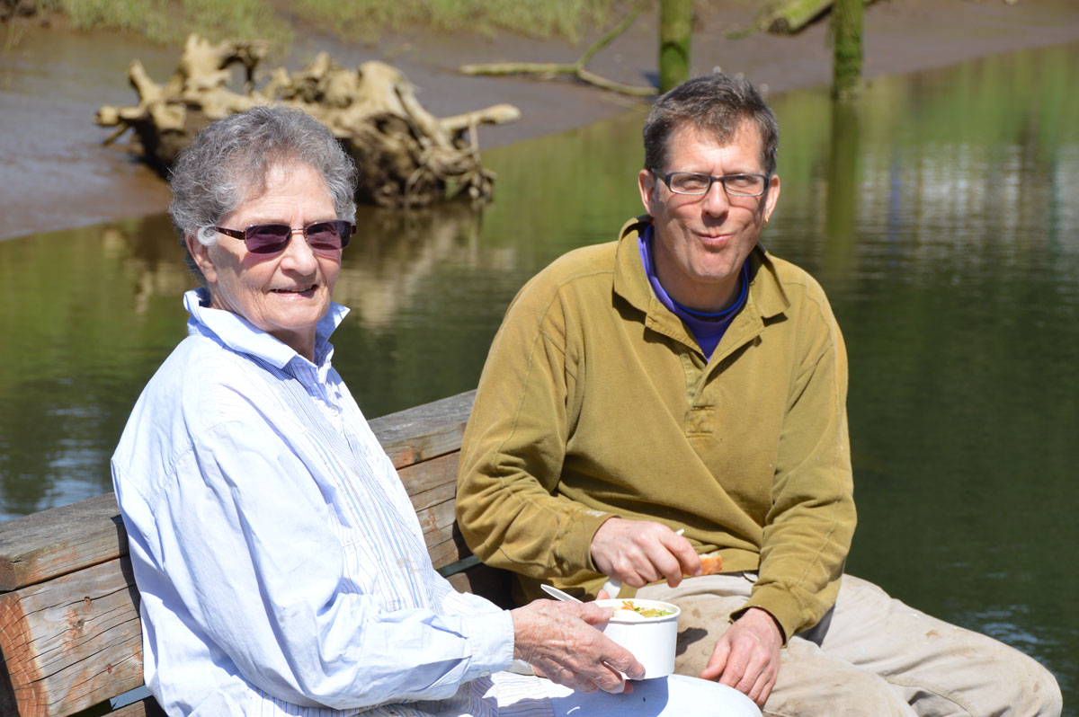 Older couple eating soup by the water