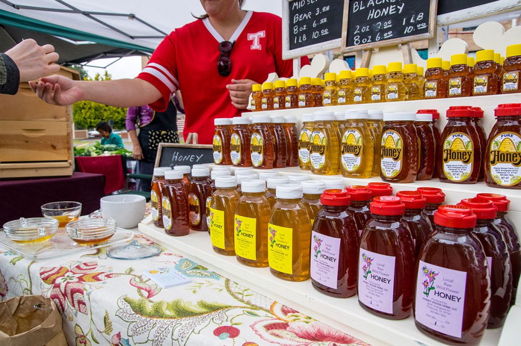 Different varieties of honey at farmers market stand