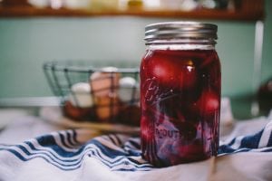 clear glass filled mason jar with lid on white and blue textile