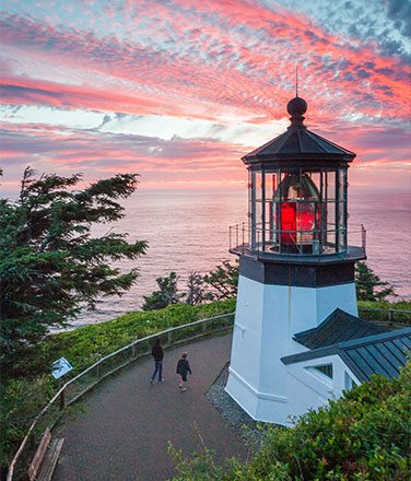 Aerial view of Cape Meares Lighthouse at sunset with pink clouds in the sky