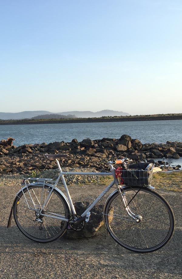 Bike parked on a gravel road next to the water