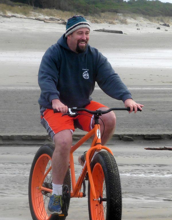 Man rides a fat tire bike on the sand