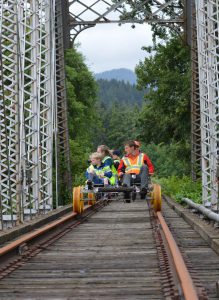 Group pedaling Oregon Railriders car over a bridge