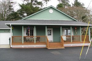 One-story, green house with porch
