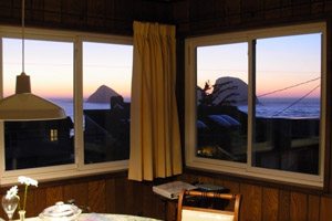 Room with windows overlooking the ocean at sunset