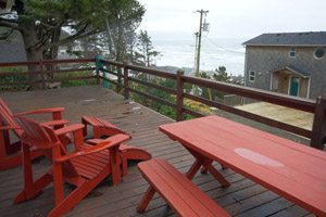 Red lounge chairs and table on balcony overlooking the ocean