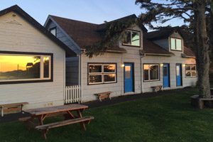 Picnic table and tree in front of two-story inn