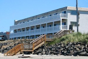 Long building off the beach with balconies in front of ocean-facing rooms