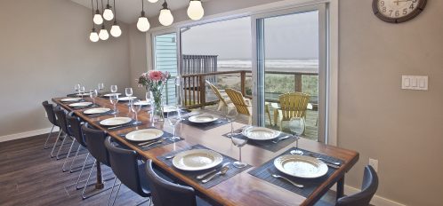 Long dining table, fully set, in front of a window