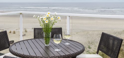 Chairs and table on porch overlooking the beach