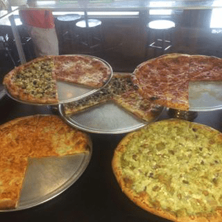 Five pizzas on serving plates