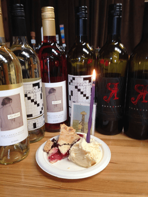 Paper plate with pie and ice cream, surrounded by full bottles of wine