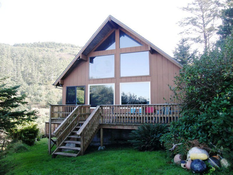 Big house in the woods with wide front porch