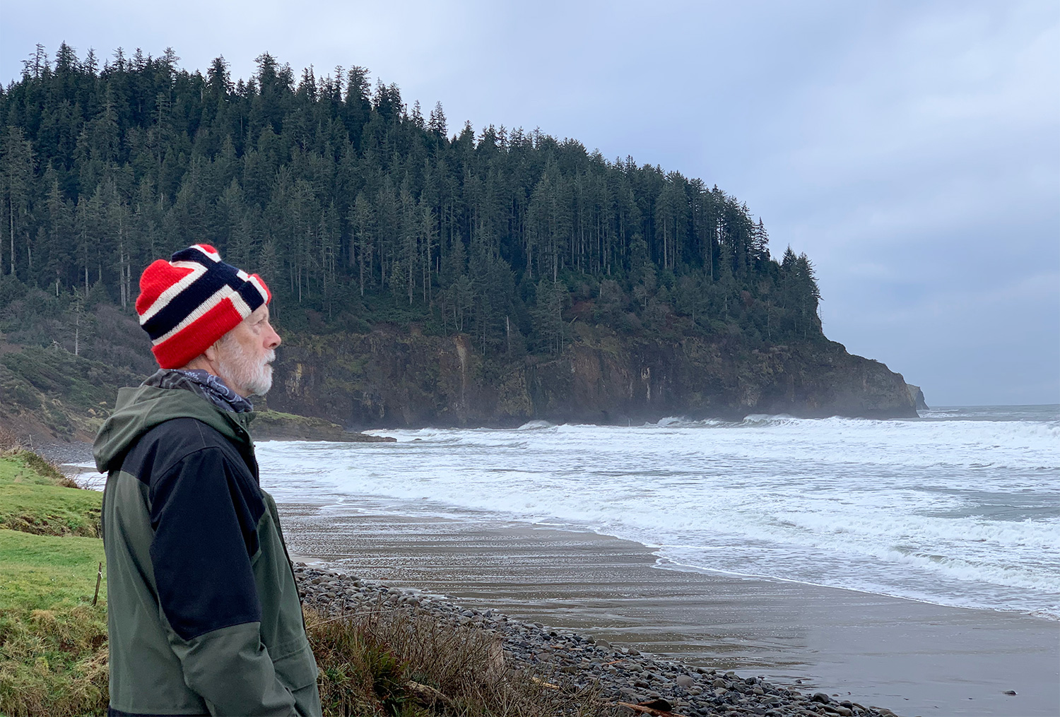 man hat looking ocean vista mountain trees