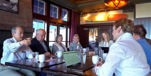 video poster meeting indoor seated people