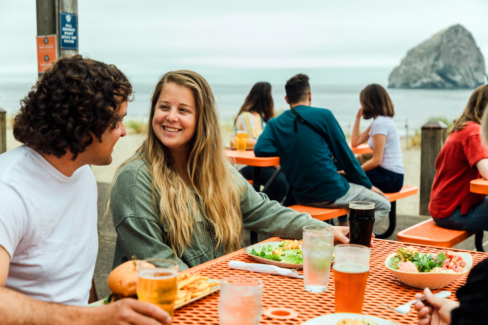pelican brewing patio lunch tables people ocean sea stack